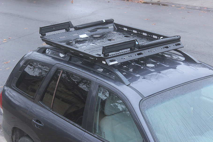 looking down at a small black revrack tray with ski racks and soft pads attached, atop a navy blue hun die